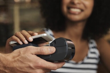 image of woman paying with phone